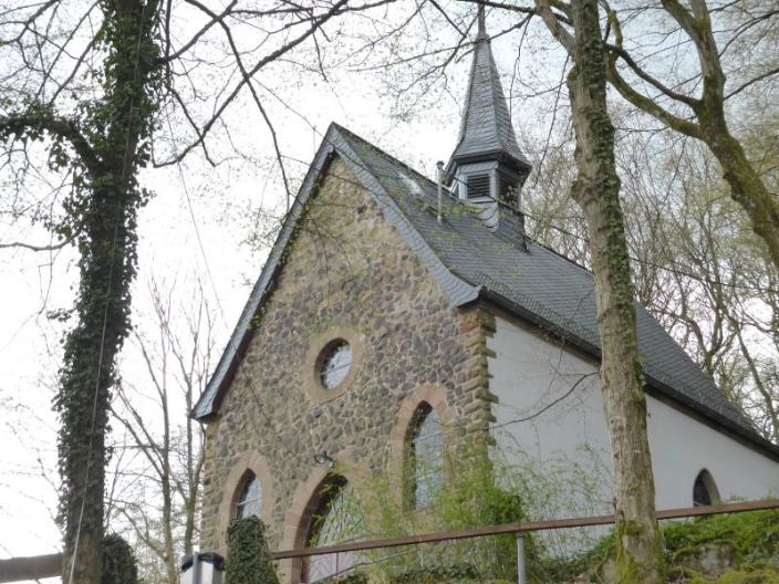 Eine kleine Kapelle auf einer Anhöhe zwischen kahlen Bäumen